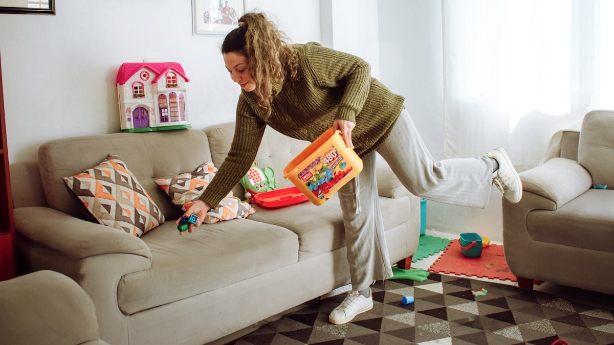 a person holding a box and a child on a couch