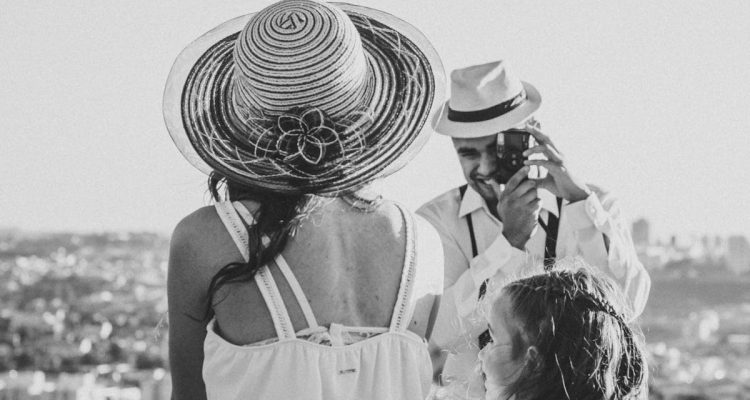 A black and white family portrait of a couple and child overlooking Sorocaba, Brazil on a sunny day.